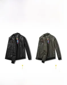 Detail of embroidered vintage badges and ribbed cuffs on the black PU flight jacket