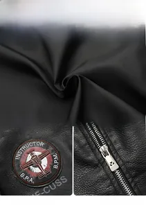 Detail of black faux leather jacket with instructor badge, embroidery and metal zipper