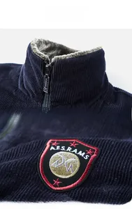 Detail showing plush fleece lining and embroidered crest on the corduroy jacket collar