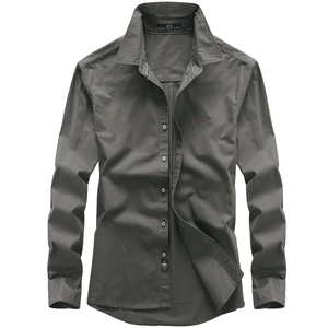Détail macro d'une chemise en coton gris anthracite avec logo brodé rouge sur le torse