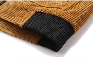 Detail view of corduroy jacket hem featuring black elastic ribbed cuff and smooth zipper