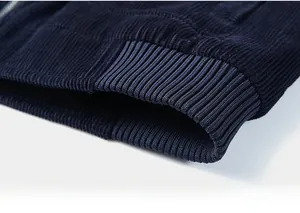 Detailed close-up of the ribbed elastic hem on a heavy navy blue corduroy jacket
