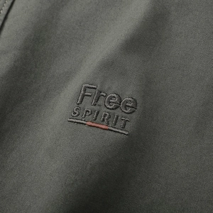 Détail de la broderie Free Spirit sur tissu sergé de coton vert olive pour chemise homme