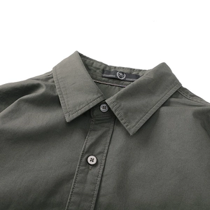 Détail du col de chemise vert olive avec texture sergée et bouton classique