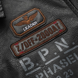 Close-up of slim fit black faux leather biker jacket with eagle embroidery and textures