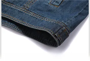 Detailed macro shot of the hem with orange double stitching on dark blue denim jacket