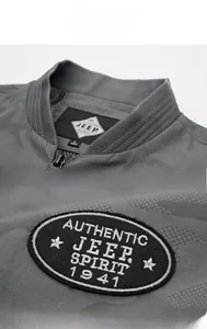 Detail of gray camouflage jacket standing collar and brand patch on shoulder sleeve