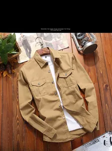 Flat lay of khaki cotton men's casual shirt with double chest pockets on vintage wood background
