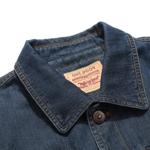 Deep blue denim jacket collar with contrast stitching and branded leather neck label