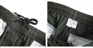 Detail of cargo pants elastic waistband with drawstring and fabric care label details