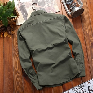 Army green men's cotton military shirt in a relaxed fit shown on a rustic wooden background