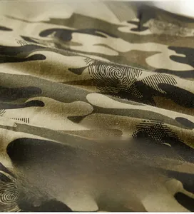 Close-up of camouflage fabric texture showing tight plain weave and jungle pattern