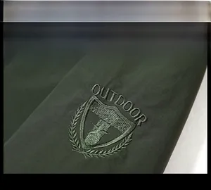 Detailaufnahme der taktischen Stickerei am Ärmel der dunkelgrünen Outdoorjacke