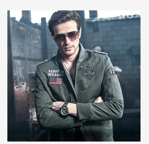 Detail showing army green pilot jacket with embroidered military patches and zip pocket
