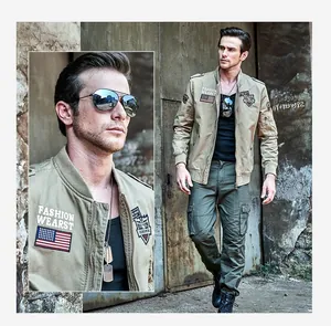 Detail of khaki military cargo jacket with embroidered patches and arm zip pocket