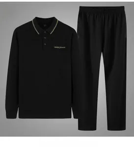 Detail view of men's black long-sleeve polo tracksuit with yellow collar patterns