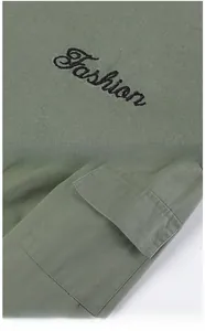 Detail of army green cargo shirt showing fine fashion embroidery and utility sleeve pocket