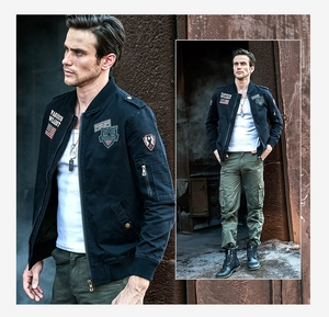 Detail of military-style cotton bomber jacket with embroidered patches and arm pocket