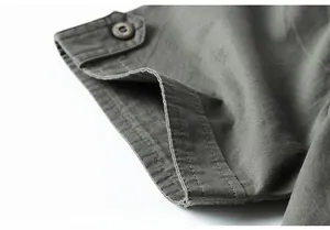 Close-up of olive cotton shirt cuff with premium stitching and vintage button detail