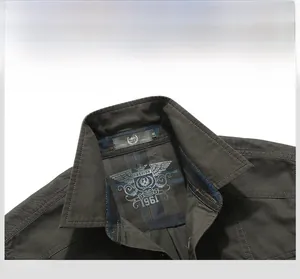 Dettaglio del colletto della camicia grigio scuro con fodera a scacchi blu e stampa