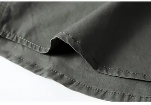 Detailed macro view of the double-stitched hem on a cotton twill men's work shirt