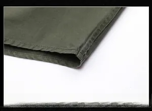 Détail de l'ourlet de la chemise en coton vert olive avec coutures à double aiguille
