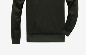 Detail view of cotton work jacket with olive green ribbed cuffs and hem texture
