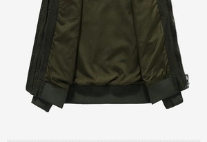 Detail of army green jacket featuring ribbed hem, cuffs and metallic side zipper