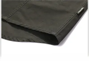 Dettaglio dell'orlo della camicia in cotone verde militare con doppia cucitura ed etichetta