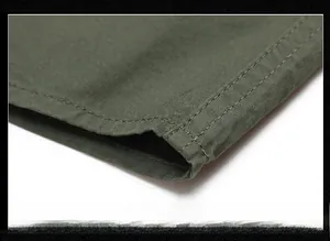 Detailed macro shot of army green cotton shirt hem showing durable double-needle stitching