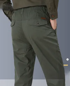 Detail of men's casual pants showing elastic waist and back flap pocket with leather logo