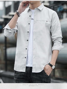 Detail of light gray men's long sleeve shirt layered over white printed tee for casual look