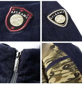 Detail of navy corduroy jacket showing embroidered shield patch and camo lining texture