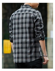 Detailed texture of grey and black plaid men's cotton shirt with subtle red stripes