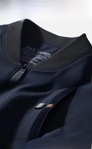 Detailed view of the ribbed stand collar and brand embroidery on the navy jacket