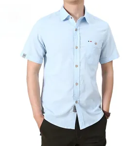 Detail of light blue short sleeve shirt featuring wooden buttons and tricolor pocket ribbon