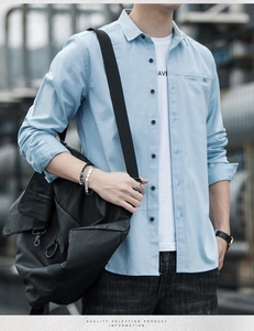 Detail of light blue casual shirt featuring a chest pocket with striped trim accents