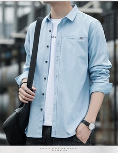 Detail of light blue men's long sleeve shirt featuring decorative chest pocket and black buttons