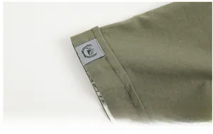 Close-up of military green short sleeve cuff with cotton texture and woven label