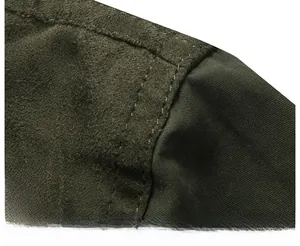 Close-up of double-stitched shoulder seams on a green suede and canvas jacket