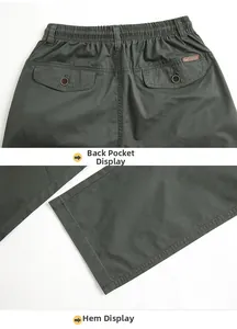 Detail of elastic waistband with button flap pocket and straight hem on olive green trousers