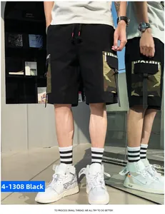 Detail of black cargo shorts with camouflage side pockets and tactical strap accents