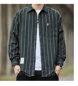 Detail of dark green and orange striped shirt featuring a chest pocket with fashion tag