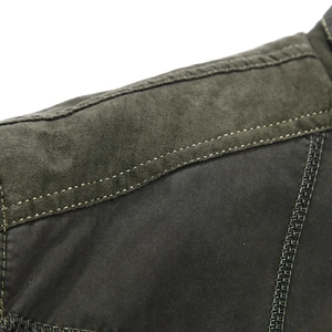 Deep olive green men's jacket featuring shoulder patchwork and yellow contrast stitching