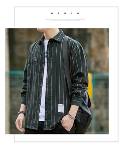 Detail of dark green men's striped flannel shirt featuring a chest pocket and stylish labels