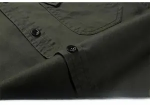 Detail of army green twill shirt fabric with branded black buttons and double stitching