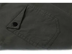 Detail shot of army green cotton shirt pocket featuring high-quality stitching and button