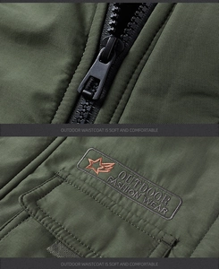 Detail of dark green outdoor vest featuring a black zipper and professional star embroidery