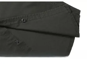 Detailed close-up of olive green shirt placket with black buttons and premium stitching