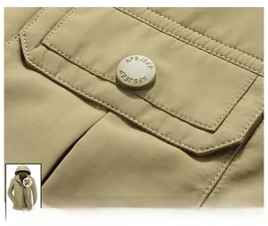 Detail der Seitentasche an der khakifarbenen Outdoorjacke mit Markenknopf und Köpergewebe